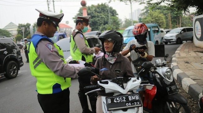 Petugas kepolisian memeriksa kelengkapan dokumen saat Operasi Patuh Jaya 2019 di Jalan Kemanggisan, Jakarta, Kamis (29/8). [Suara.com/Arya Manggala]
