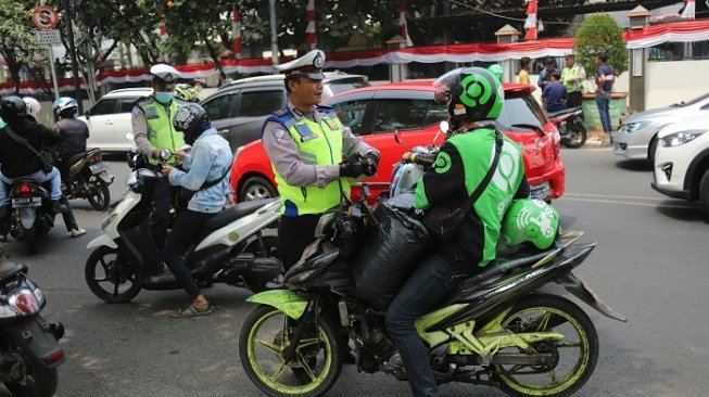 Tak hanya pengendara biasa, sejumlah pengemudi ojek online tak luput dari razia polisi saat Operasi Patuh Jaya 2019 di Jalan Kemanggisan, Jakarta, Kamis (29/8). [Suara.com/Arya Manggala]