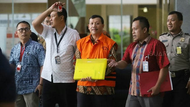 Sekretaris Daerah Jawa Barat Iwa Karniwa mengenakan rompi tahanan seusai menjalani pemeriksaan di Gedung KPK, Jakarta, Jumat (30/8). [Suara.com/Arya Manggala]
