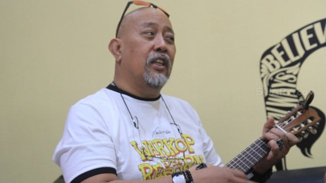 Indro warkop memainkan ukulele saat berkunjung ke kantor Redaksi Suara.com, Jakarta, Jumat (30/8). [Suara.com/Oke Atmaja]