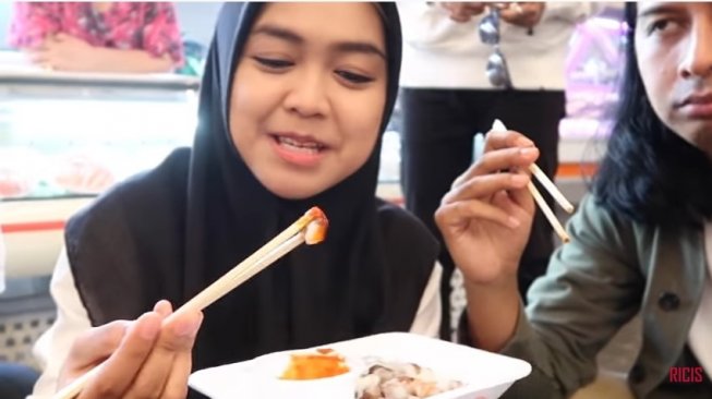 Ria Ricis makan gurita di Korea Selatan dan mendapat kecaman dari warganet.[YouTube Ria Ricis]