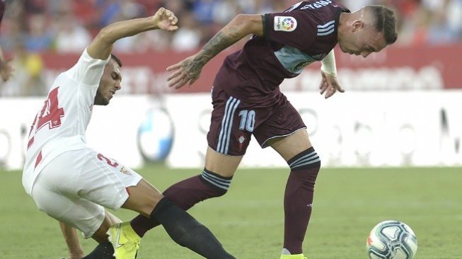 Gelandang Sevilla Joan Moreno (kiri) berebut bola dengan penyerang Celta Vigo, Lago Aspas di lanjutan Liga Spanyol, Sabtu (31/8) dini hari WIB, skor berakhir imbang 1-1. (AFP)