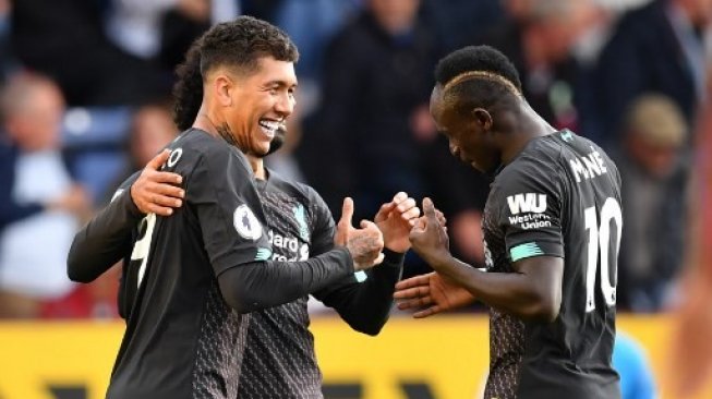 Pemain Liverpool Roberto Firmino (kiri) merayakan golnya ke gawang Burnley dalam lanjutan Liga Inggris di Turf Moor. Paul ELLIS / AFP