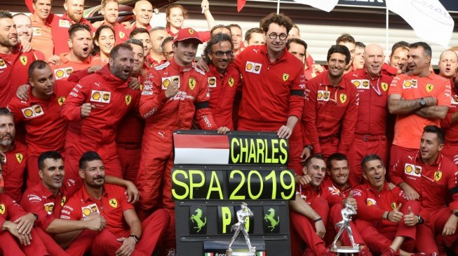 Pebalap Ferrari, Charles Leclerc, merayakan keberhasilannya menjuarai F1 GP Belgia 2019 di Sirkuit Spa bersama kru timnya, Minggu (1/9). [AFP/John Thys]