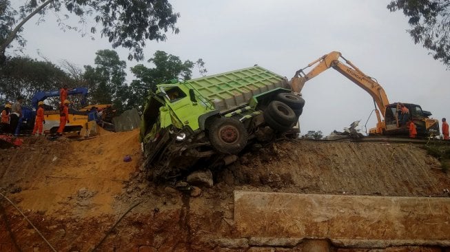 Petugas mengevakuasi salah satu kendaraan yang terlibat pada kecelakaan beruntun di Tol Cipularang KM 92 Purwakarta, Jawa Barat, Senin (2/9). [ANTARA FOTO/Ibnu Chazar]