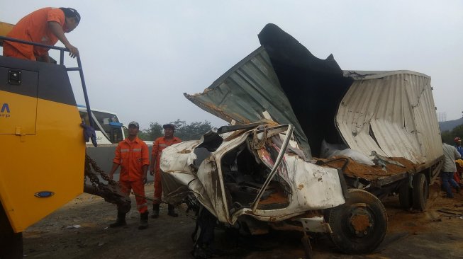 Petugas mengevakuasi salah satu kendaraan yang terlibat pada kecelakaan beruntun di Tol Cipularang KM 92 Purwakarta, Jawa Barat, Senin (2/9). [ANTARA FOTO/Ibnu Chazar]