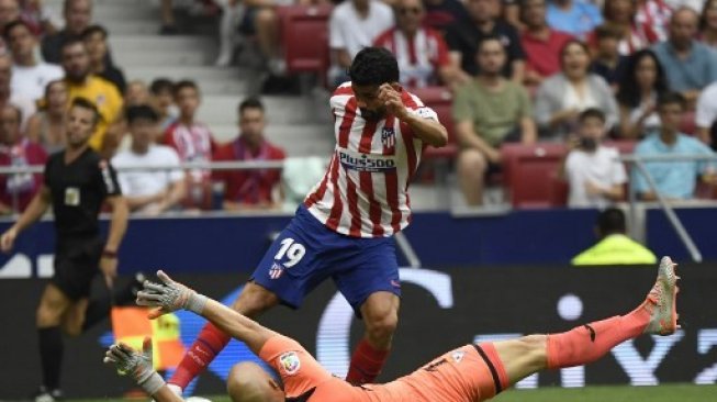 Pemain Atletico Madrid Diego Costa berhadapan dengan penjaga gawang Eibar dalam pertandingan La Liga yang berlangsung di Wanda Metropolitano, Senin (2/9/2019). [AFP]