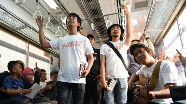 Grup band D'Masiv menghibur pengguna jasa KRL dari stasiun Manggarai menuju Stasiun Jakarta Kota, Senin (2/9). [Suara com/Arya Manggala]