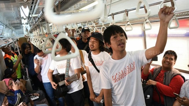 Grup band D'Masiv menghibur pengguna jasa KRL dari stasiun Manggarai menuju Stasiun Jakarta Kota, Senin (2/9). [Suara com/Arya Manggala]