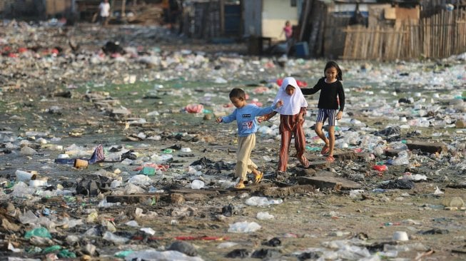 Anak-anak bermain di atas tumpukan sampah di kawasan Kampung Bengek, Penjaringan, Jakarta Utara, Selasa (3/9). [Suara.com/Arya Manggala] 