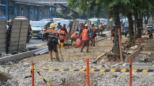 Pekerja menyelesaikan proyek revitalisasi trotoar di Jalan Salemba, Jakarta Pusat, Selasa (3/9). (Suara.com/Angga Budhiyanto)