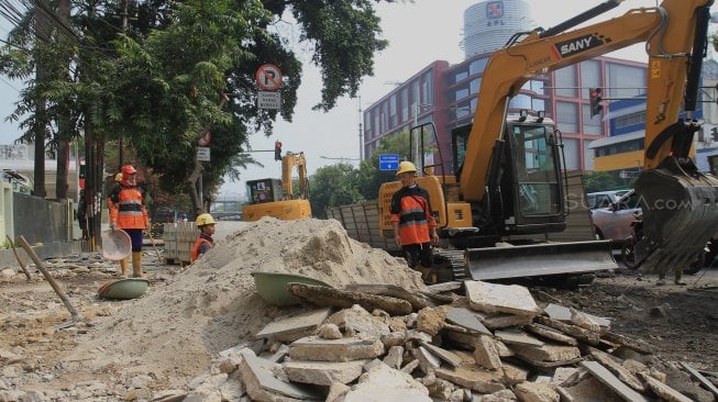 Pekerja menyelesaikan proyek revitalisasi trotoar di Jalan Salemba, Jakarta Pusat, Selasa (3/9). (Suara.com/Angga Budhiyanto)