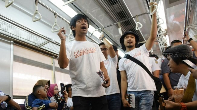 Grup band D'Masiv menghibur pengguna jasa KRL dari stasiun Manggarai menuju Stasiun Jakarta Kota, Senin (2/9). [Suara com/Arya Manggala]