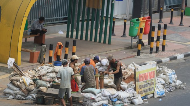 Sejumlah pekerja menggali lubang kabel fiber optik di Jalan Matraman, Jakarta, Selasa (3/9). (Suara.com/Angga Budhiyanto)