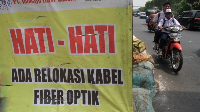 Sejumlah pekerja menggali lubang kabel fiber optik di Jalan Matraman, Jakarta, Selasa (3/9). (Suara.com/Angga Budhiyanto)