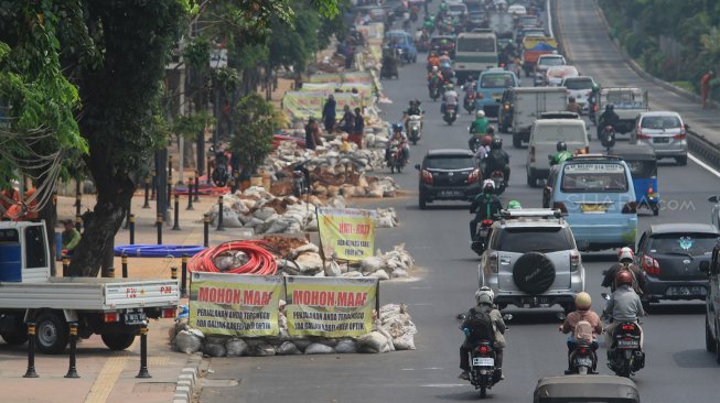 Sejumlah pekerja menggali lubang kabel fiber optik di Jalan Matraman, Jakarta, Selasa (3/9). (Suara.com/Angga Budhiyanto)