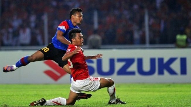 Striker Timnas Malaysia, Mochamad Safee (kiri), duel dengan bek Timnas Indonesia, Hamkah Hamzah (C), selama final leg kedua AFF Suzuki Cup 2010 di Jakarta pada 29 Desember 2010. (AFP/ ADEK BERRY).