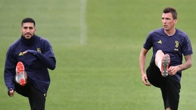 Gelandang Juventus Emre Can (kiri) dan Mario Mandzukic sedang melakukan sesi latihan menjelang laga Liga Champions. Marco BERTORELLO / AFP