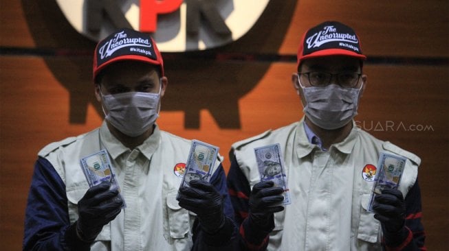 Penyidik KPK menunjukan barang bukti uang pecahan dolar AS saat konferensi pers terkait operasi tangkap tangan (OTT) Bupati Muara Enim Ahmad Yani di Gedung KPK Jakarta, Selasa (3/9)(Suara.com/Angga Budhiyanto)
