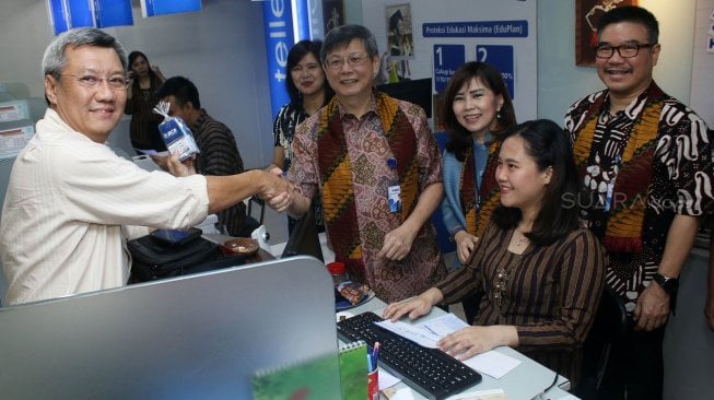 Direktur PT Bank Central Asia Tbk (BCA) Henry Koenaifi (kedua kiri) dan Lianawaty Suwono (tengah) didampingi oleh Kepala Kantor Wilayah X BCA Lukman (kanan) menyapa nasabah sebagai bentuk ungkapan terima kasih atas kesetiaan nasabah menggunakan layanan dan produk perbankan BCA di BCA Kantor Cabang Utama (KCU) Pasar Baru, Rabu (04/09). [Suara.com/Oke Atmaja]