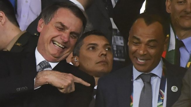 Legenda Brasil, Cafu (kanan) bersama Presiden Brasil, Jair Bolsonaro bersenda gurau pada gelaran Copa America 2019. (Nelson ALMEIDA / AFP)