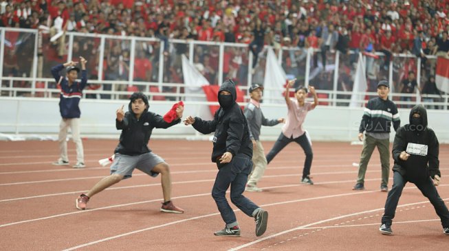 Suporter Indonesia berusaha menyerang suporter Malaysia saat pertandingan timnas Indonesia melawan timnas Malaysia pada Kualifikasi Piala Dunia 2022 Grup G Zona Asia di Stadion Gelora Bung Karno (GBK), Senayan, Jakarta, Kamis (5/9). [Suara.com/Arya Manggala]