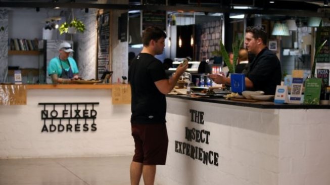 Chef Mario melayani seorang pelanggan yang membeli bumbu dari cacing mopane di Restoran Insect Experience di Cape Town, Afrika Selatan (Foto: Reuters)