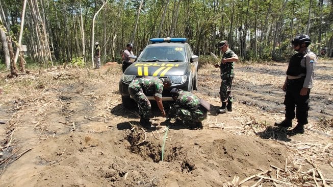 Personel Polri dan TNI mengevakuasi bom latih yang jatuh di areal tebu di Pasirian, Lumajang, Jawa Timur, Jumat (6/9). [ANTARA FOTO/Iwan]