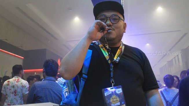 Direktur PT Stig Vape Indonesia Wiliam Martaputra menggunakan produk dari STIG Vape pada gelaran "Vape Fair" di JCC, Jakarta, Sabtu (7/9).(Suara.com/Angga Budhiyanto)