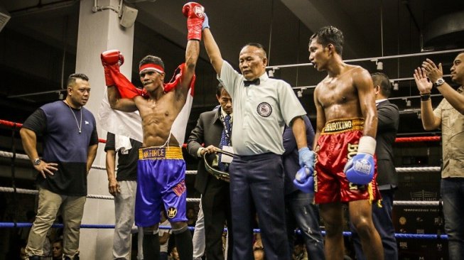 Petinju muda andalan Indonesia, Ongen Saknosiwi (kiri) merebut gelar juara kelas bulu versi WBC Asian Boxing Council Continental setelah memukul KO petinju Thailand, Nanthawat Mailochat di Singapura, Sabtu (7/9/2019) malam. [Dok. Mahkota Promotion]