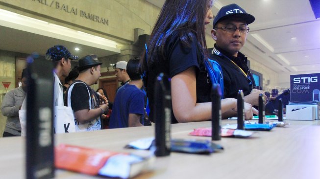 Kelik Irwantono (kanan) selaku President Director/CEO PT Stig Vape Indonesia didampingi Sales Promotion Girl (SPG) mengecek ketersediaan stok barang saat acara "Vape Fair" di JCC, Jakarta, Sabtu (8/9). [Suara.com/Angga Budhiyanto]