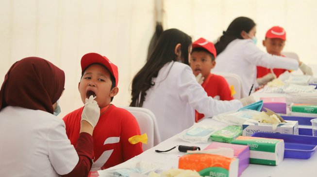 Dokter Gigi memeriksa gigi seorang siswa Sekolah Dasar dalam gerakan Indonesia Tersenyum di Bulan Kesehatan Gigi Nasional (BKGN) 2019 di Jakarta, Sabtu (7/9). [Suara.com/Arya Manggala] 