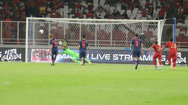 Pemain Timnas Thailand, Theerathon Bunmathan (kiri) mencetak gol penalti ke gawang Timnas Indonesia dalam laga putaran kedua kualifikasi Piala Dunia 2022 Zona Asia Grup G di Stadion Utama Gelora Bung Karno, Selasa (10/9/2019). [Suara.com/Arya Manggala]