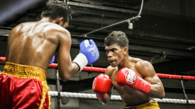 Petinju Indonesia Ongen Saknosiwi (kanan) menghadapi petinju Thailand, Nanthawat Mailochat, dalam duel perebutan sabuk WBC Asia Boxing Council Continental di The Ring Boxing Community, Singapura, Sabtu (7/9/2019). [Dok. Mahkota Promotion]