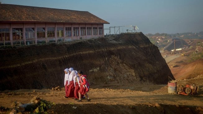 Sejumlah siswi berjalan menuju SDN Cijolang yang terdampak proyek Tol Cisumdawu di Tanjungsari, Kabupaten Sumedang, Jawa Barat, Selasa (10/9).  [ANTARA FOTO/Raisan Al Farisi]
