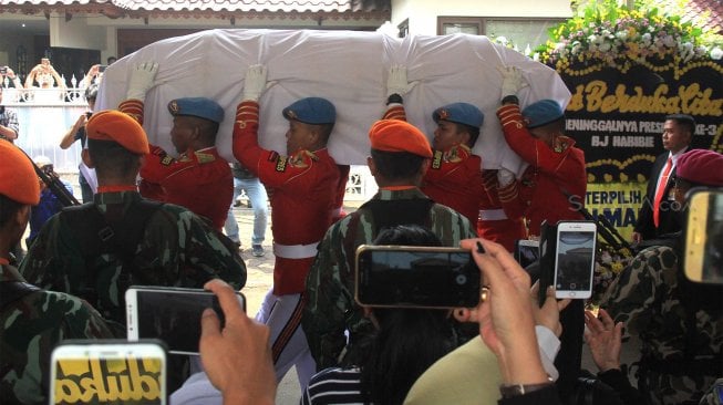 Personel Pasukan Pengamanan Presiden (Paspampres) mengusung peti jenazah almarhum Presiden ke-3 Republik saat prosesi penyerahan jenazah BJ Habibie di rumah duka kawasan Patra Kuningan, Jakarta, Kamis (12/9).[Suara.com/Angga Budhiyanto]