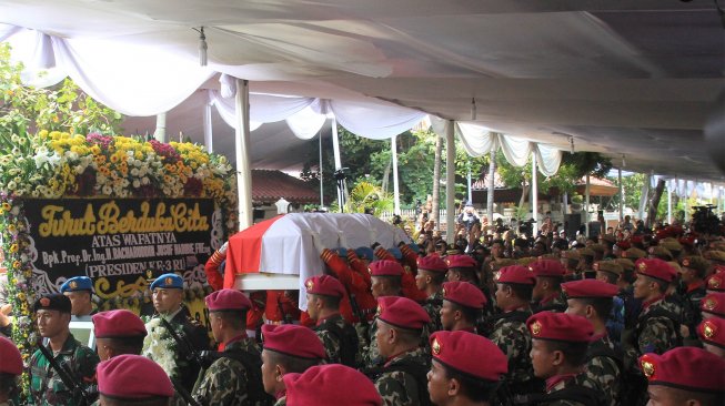 Personel Pasukan Pengamanan Presiden (Paspampres) mengusung peti jenazah almarhum Presiden ke-3 Republik saat prosesi penyerahan jenazah BJ Habibie di rumah duka kawasan Patra Kuningan, Jakarta, Kamis (12/9).[Suara.com/Angga Budhiyanto]