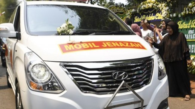 Warga melambaikan tangan ke mobil jenazah yang membawa almarhum Presiden ke-3 Republik Indonesia BJ Habibie saat berjalan menuju Taman Makam Pahlawan Nasional Utama Kalibata dari rumah duka di kawasan Patra Kuningan, Jakarta, Kamis (12/9/2019). BJ Habibie meninggal dunia pada hari Rabu (11/9/2019) pukul 18.05 WIB setelah menjalani perawatan di RSPAD dan akan dimakamkan di Taman Makam Pahlawan Nasional Utama Kalibata, Jakarta [ANTARA FOTO/Hafidz Mubarak A/wsj].