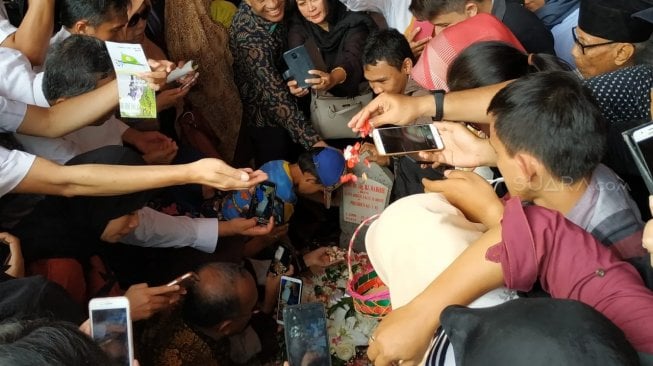 Usai pemakaman, warga yang menghadiri upacara tersebut mendatangi pusara Habibie untuk berfoto. (Suara.com/Fakhri Fuadi)