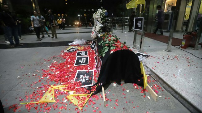 Sejumlah aktivis Koalisi Masyarakat Sipil menaburkan bunga pada keranda di Gedung KPK, Jakarta, Jumat (13/9). [Suara.com/Arya Manggala]