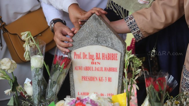 Warga berdoa saat berziarah di makam BJ Habibie di Taman Makam Pahlawan Nasional Kalibata, Jakarta, Sabtu (14/9). [Suara.com/Arya Manggala]