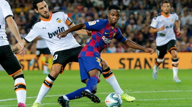 Pemain muda Barcelona, Ansu Fati mencuri perhatian dengan tampil menawan saat melakoni debutnya. Ia tak hanya mencetak gol, tapi juga mampu memberi assist di laga Barcelona kontra Valencia, Minggu (15/9/2019) dini hari tadi. [Pau Barrena / AFP]