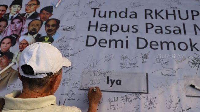 Sejumlah massa yang tegabung dalam Aliansi Masyarakat Sipil Untuk Keadilan dan Demokrasi melakukan unjuk rasa di kawasan Bundaran HI, Jakarta, Minggu (15/9). [Suara.com/Angga Budiyanto]  
