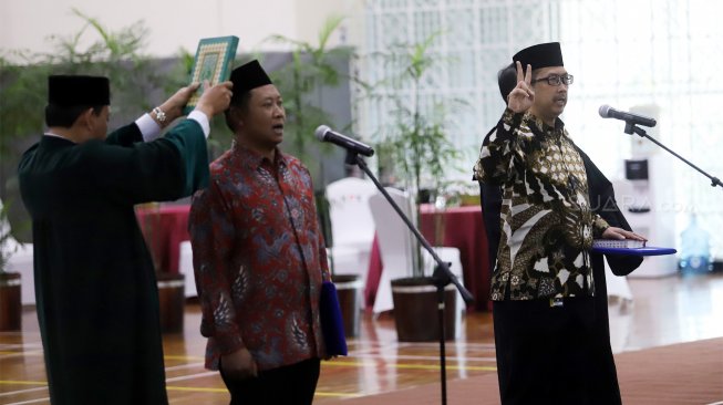 Fitroh Roncohyanto (kiri) bersama dengan Cahya Harefa (kanan) melakukan sumpah saat pelantikan Sekjen dan Direktur Penuntut KPK yang baru di Gedung Merah Putih KPK, Jakarta, Senin (16/9). (Suara.com/Angga Budhiyanto)