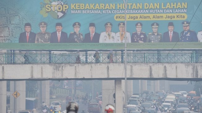 Pengguna jalan melintasi salah satu ruas jalan di kota Palembang, Sumsel, Senin (16/9). [ANTARA FOTO/Feny Selly]