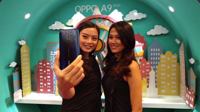 Dua orang model sedang berfoto menggunakan ponsel Oppo A 2020 di Jakarta, Selasa (17/9/2020). [Suara.com/Tivan Rahmat]
