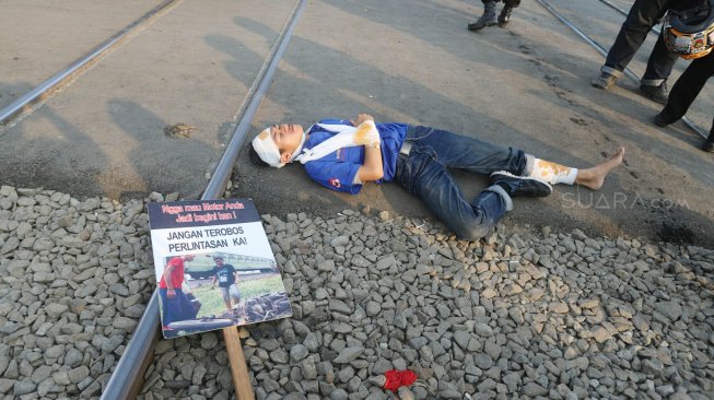 Petugas KAI Daop 1 Jakarta melakukan sosialisasi keselamatan di perlintasan sebidang Bukit Duri Manggarai, Jakarta, Selasa (17/9). [Suara.com/Arya Manggala]