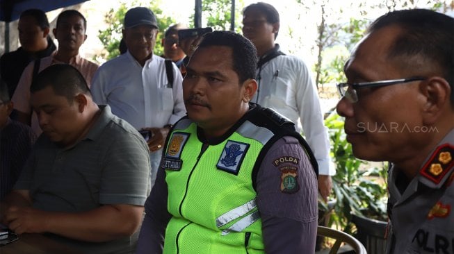 Bripka Eka Setiawan (tengah) bersiap melakukan jumpa pers di halaman Gedung Biru Polda Metro Jaya, Jakarta, Selasa (17/9). [Suara.com/Angga Budhiyanto]