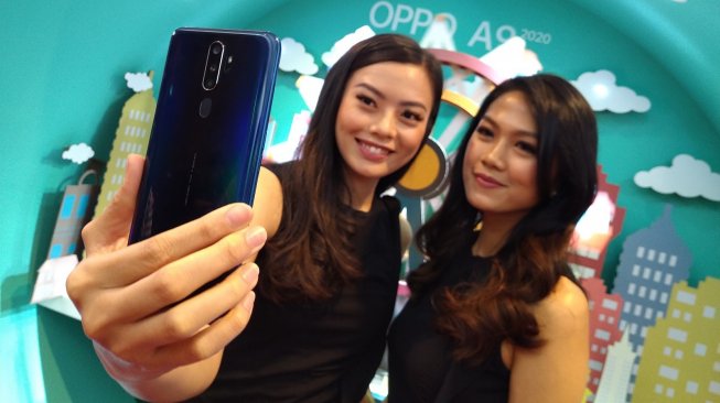 Dua orang model sedang berfoto menggunakan ponsel Oppo A 2020 di Jakarta, Selasa (17/9/2020). [Suara.com/Tivan Rahmat]