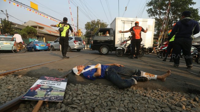 Petugas KAI Daop 1 Jakarta melakukan sosialisasi keselamatan di perlintasan sebidang Bukit Duri Manggarai, Jakarta, Selasa (17/9). [Suara.com/Arya Manggala]